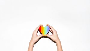 LGBT - Hand einer Frau hält ein Regenbogen-Pride-Symbol